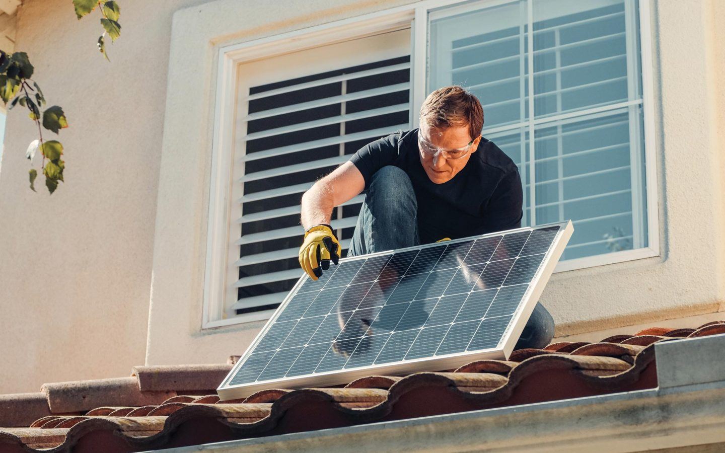 a man installing a solar panel on a residential roof