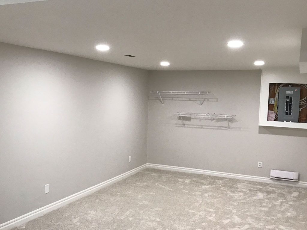 a carpeted basement with pot lighting