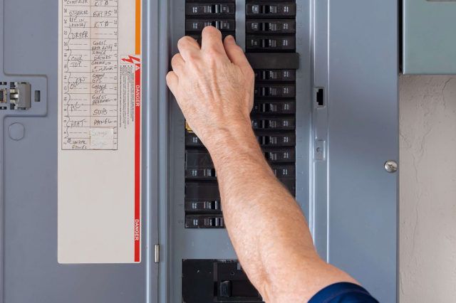 close up photo of a hand working in an electrical panel