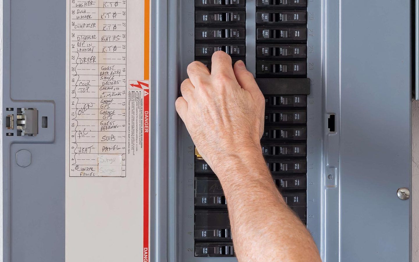 close up photo of a hand working in an electrical panel