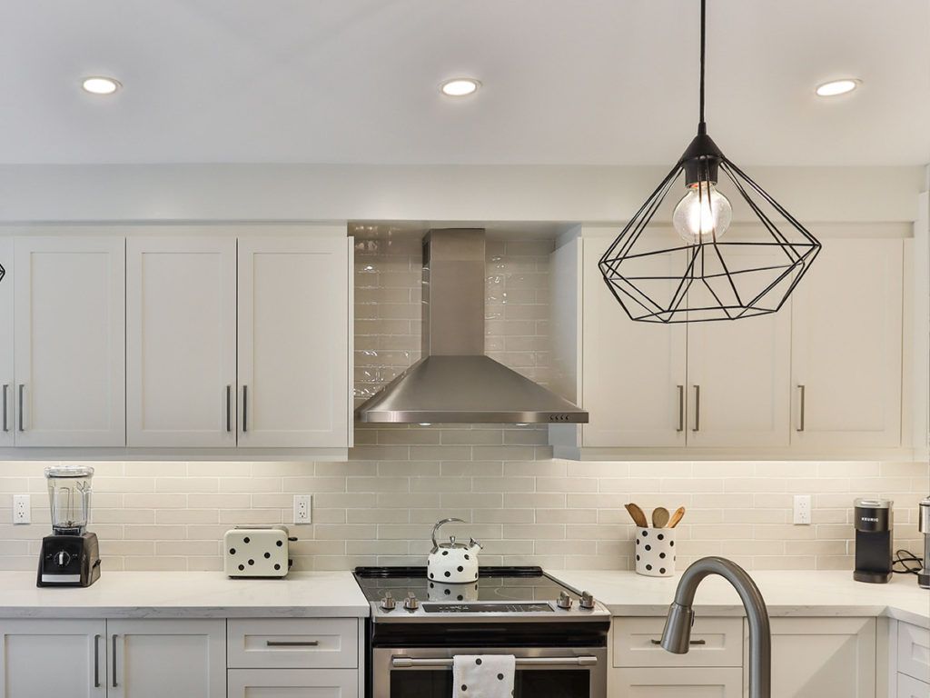 a kitchen with white cabinets and counter tops