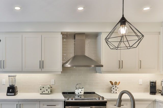 a kitchen with white cabinets and counter tops