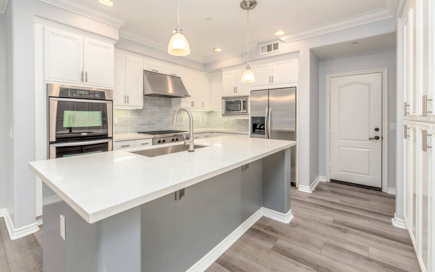 a large kitchen with a center island and stainless steel appliances